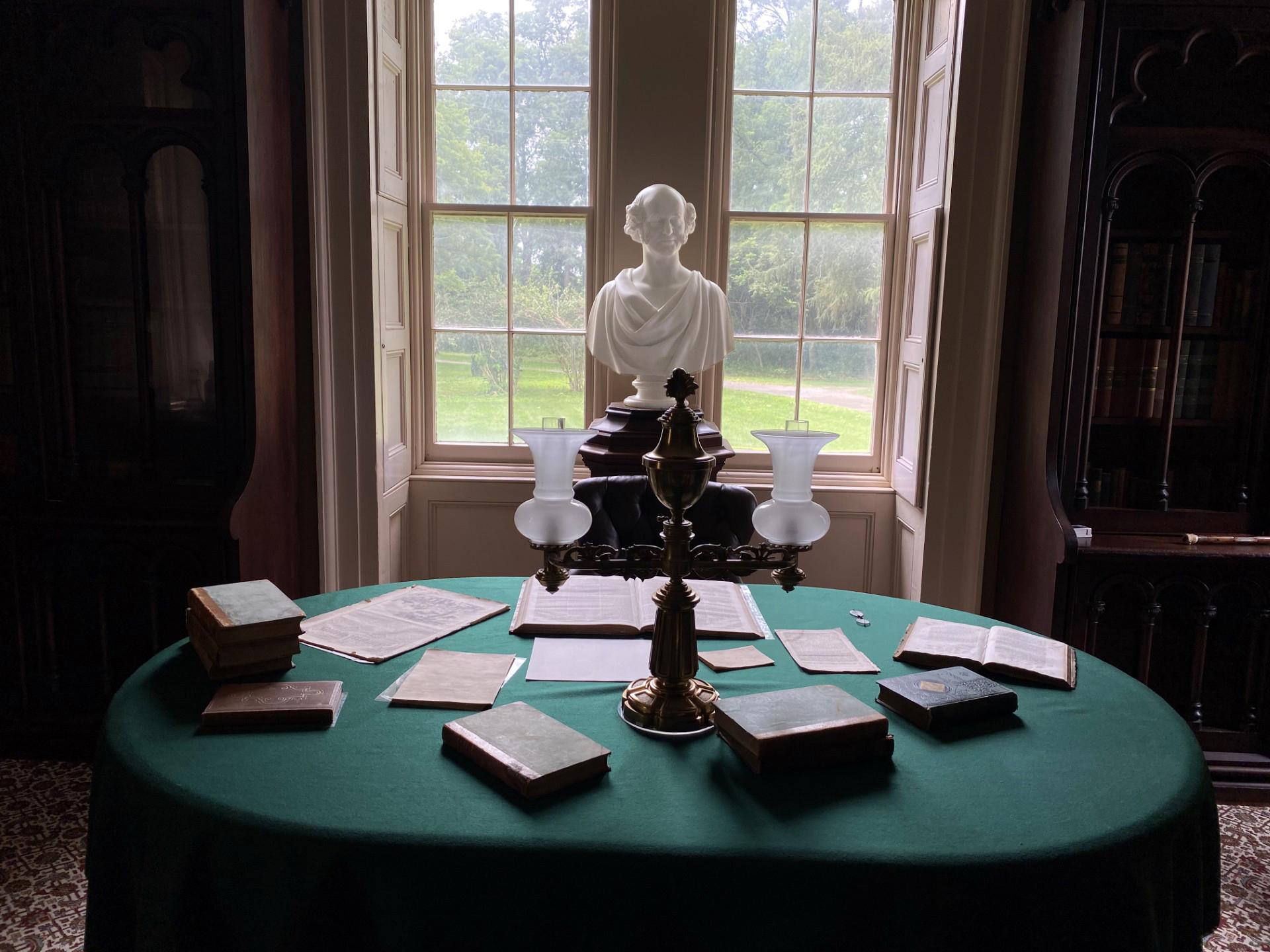 A white marble bust of Martin Van Buren is centered between two windows and behind an oblong desk.